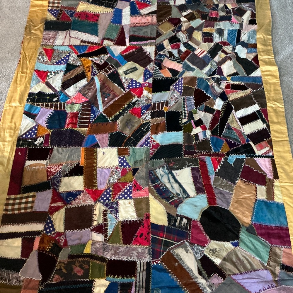 Antique silk crazy quilt. Simple red backing, intricate stitching. Small imperfe